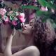 Beautiful portrait of a young woman smelling pink camellia flowers... (thumbnail)