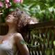 Sensual portrait of a beautiful woman touching blooming pink camellia... (thumbnail)