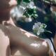 Sensual romantic closeup of a nude woman body touching gentle flowers... (thumbnail)