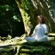 Woman in white clothes meditating in the nature in a deep green forest... (thumbnail)
