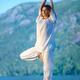 Woman practicing yoga Vrksasana standing tree pose at sunrise in the n... (thumbnail)
