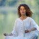 Woman meditating with a quartz crystal singing bowl in the morning by... (thumbnail)