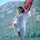 Woman practicing Tai Chi crane stance with a fan at the mountain lake... (thumbnail)