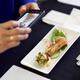 Person hands taking pictures of a gourmet seafood meal at a restaurant... (thumbnail)