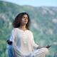 Woman meditating in the morning sunrise in the nature... (thumbnail)