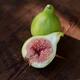Organic fresh ripe figs on a table one fruit sliced in half showing pu... (thumbnail)