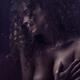 Sensual art nude portrait of a woman covering her breasts behind wet w... (thumbnail)