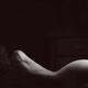 Black and white outline of a nude woman back silhouette in dark bedroo... (thumbnail)