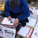 Japanese street artist calligrapher writing a name in Kanji characters... (thumbnail)