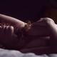 Sensual nude portrait of a woman lying naked in bed with her hand on h... (thumbnail)