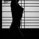 Silhouette of a beautiful naked woman standing by shoji window Black a... (thumbnail)