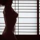 Fine art nude silhouette of a woman standing naked in light of glowing... (thumbnail)