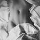 Sensual black and white of a nude woman body partially uncovered in be... (thumbnail)