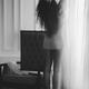 Young woman in underwear with bare legs stretching by the window in mo... (thumbnail)