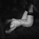 Black and white art nude body portrait of a woman in stockings lying i... (thumbnail)