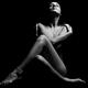 Naked woman sitting with her arms and legs crossed in front of her bod... (thumbnail)