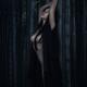Beautiful half nude asian woman leaning against a bamboo in dark fores... (thumbnail)