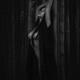 Beautiful half nude asian woman leaning against a bamboo in dark fores... (thumbnail)