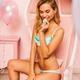 Smiling sexy blond woman in a pink chair wearing blue lingerie and bit... (thumbnail)
