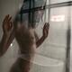 Nude woman standing behind a wet shower glass dramatic portrait... (thumbnail)