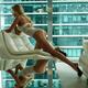Sexy woman in white lingerie leaning on a chair by a window with offic... (thumbnail)