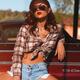 Sexy young woman in a shirt and shorts sitting on a bumper a retro car... (thumbnail)