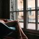 Sensual closeup of bare legs of a woman sitting naked in a chair by a... (thumbnail)