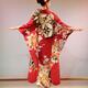 Japanese woman in a red kimono with long sleeves and an intricate gold... (thumbnail)