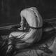 Nude woman sitting curled on the floor with an Ankh cross on her back... (thumbnail)