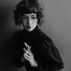 Portrait of a young woman in black with a curly bob style hair and a t... (thumbnail)