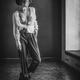 Young woman in combat boots standing topless in empty room in unbutton... (thumbnail)