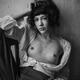Artistic nude portrait of a woman with an expressive look sitting topl... (thumbnail)