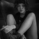 Young woman in black combat boots with bare legs sitting in a chair wi... (thumbnail)