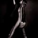 Japanese woman in black kimono revealing side of her nude body standing in a graceful pose Sepia toned