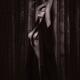 Beautiful half nude Japanese woman in undone kimono leaning against ba... (thumbnail)