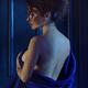 Woman holding bed sheets wrapped around her nude body revealing her na... (thumbnail)