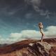 Nude woman standing gracefully on rocks in mountain landscape scenery... (thumbnail)