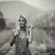 Expressive portrait of a blond woman in a summer dress standing on cou... (thumbnail)