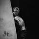 Sensual black and white portrait of a topless woman leaning against a... (thumbnail)