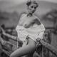 Black and white fine art portrait of a young topless woman posing on a... (thumbnail)