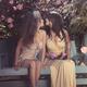 Two young women cute lesbian couple kissing on a bench in summer garde... (thumbnail)
