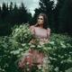 Beautiful woman in pink dress and crown walking in a field of wild yar... (thumbnail)