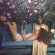 Romantic lesbian couple resting on a bench in a garden woman reading a... (thumbnail)