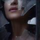 Woman face visible through a hole in a window looking through broken g... (thumbnail)