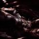 Nude woman body with sexy metallic skin lying in dark water... (thumbnail)