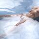 Beautiful nude woman lying in reflective water with her chest arching... (thumbnail)
