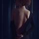 Sensual boudoir portrait a woman in black dress with low cut pulling i... (thumbnail)