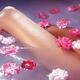 Romantic closeup of bare woman legs in a bath with pink roses floating... (thumbnail)