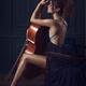 Beautiful sensual woman with a cello and a dreamy expression in elegan... (thumbnail)