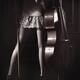 Legs of a sexy young woman in a night gown holding a cello in a dark r... (thumbnail)